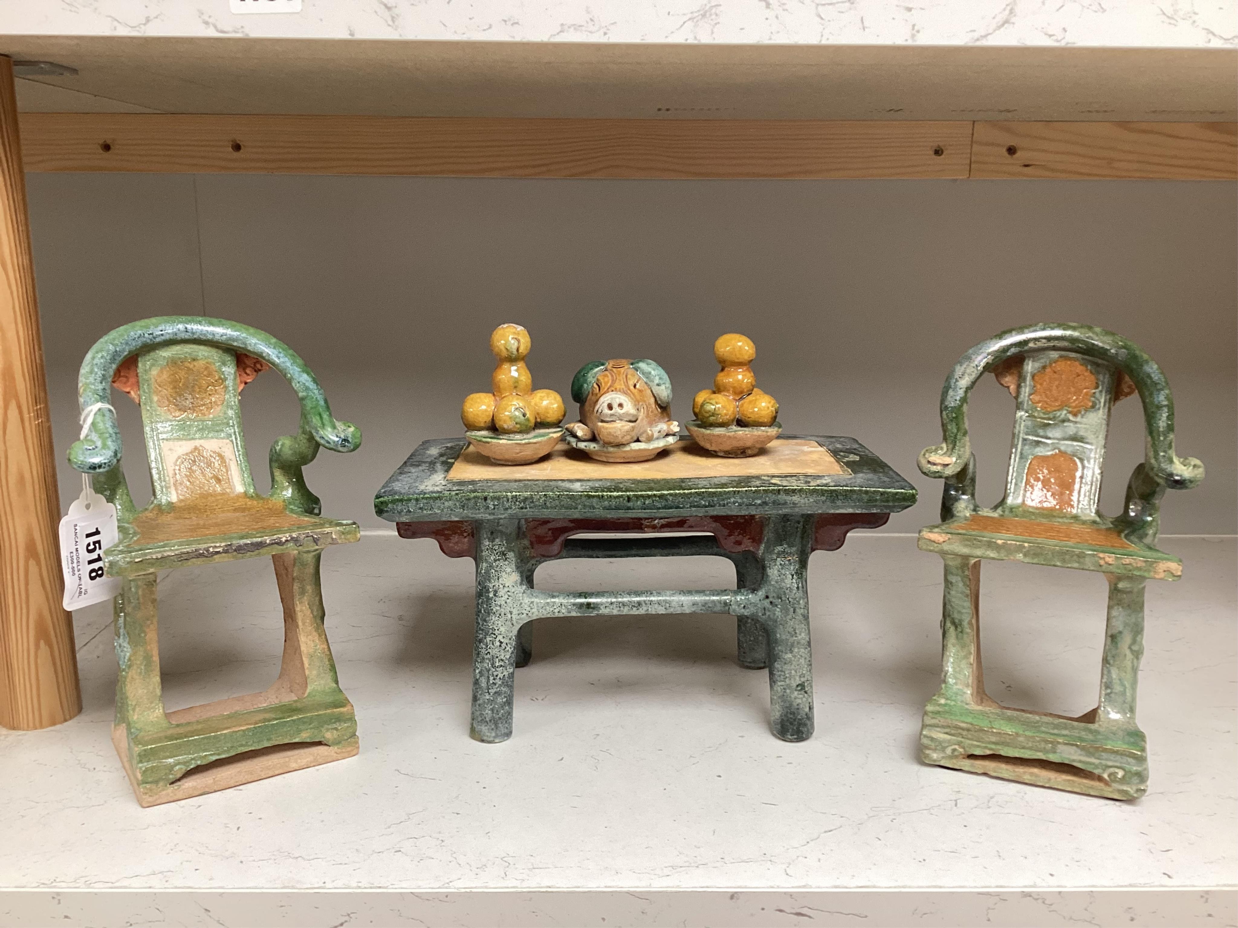 A set of Chinese Ming Sancai models of table with offerings and a pair of horseshoe shaped armchairs, 16th century, the chairs each 22cm high